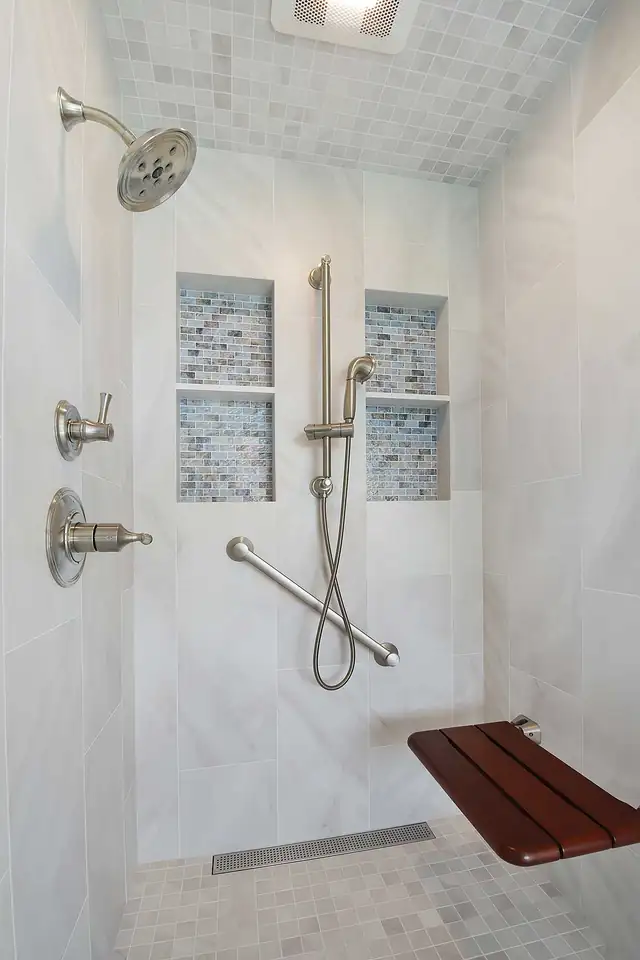Aging-in-place primary bathroom in Danville, CA with curbless marble shower, grab bars and fold-down teak seat