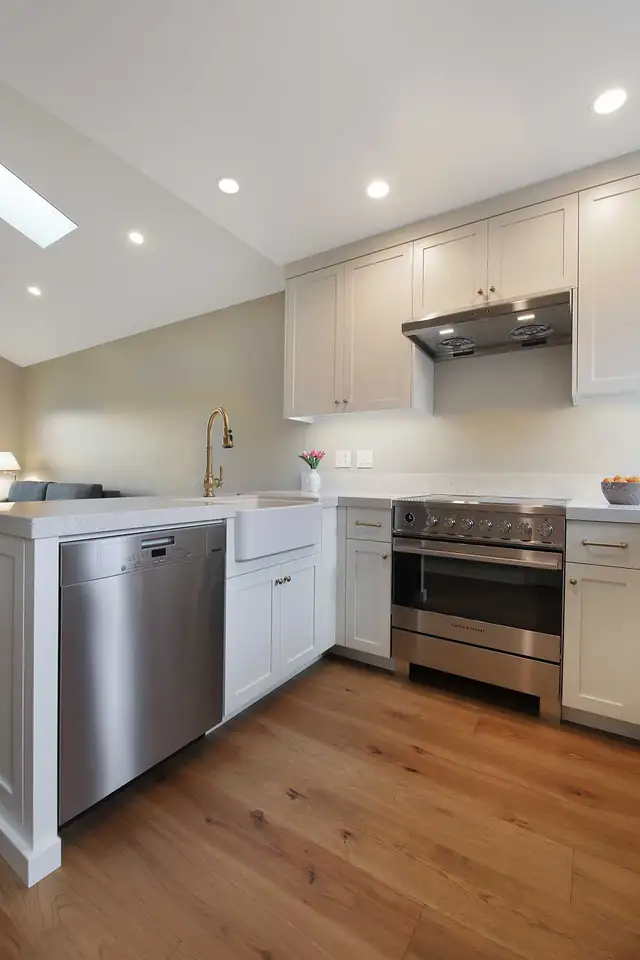 Kitchen inside a family ADU in Alamo, CA with white cabinets, stainless range and wood floors