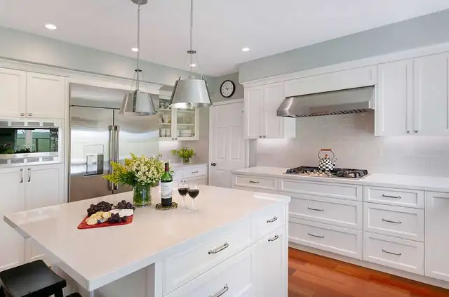 Transitional kitchen remodel in Danville, CA with white Shaker cabinets, large island and stainless pendant lights