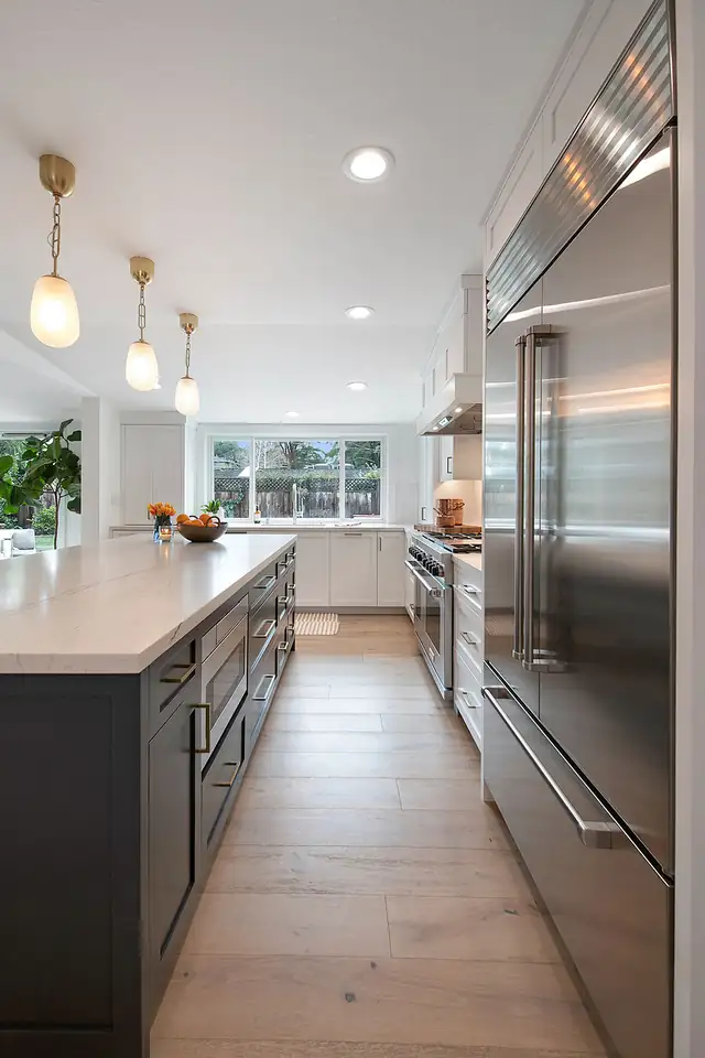 Modern ranch kitchen and great room remodel in Lafayette, CA with navy cabinets, brass hardware and quartzite counters