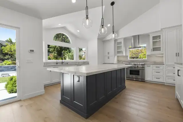 Danville, CA whole home remodel with white cabinets, a charcoal island, glass pendant lights and light oak floors