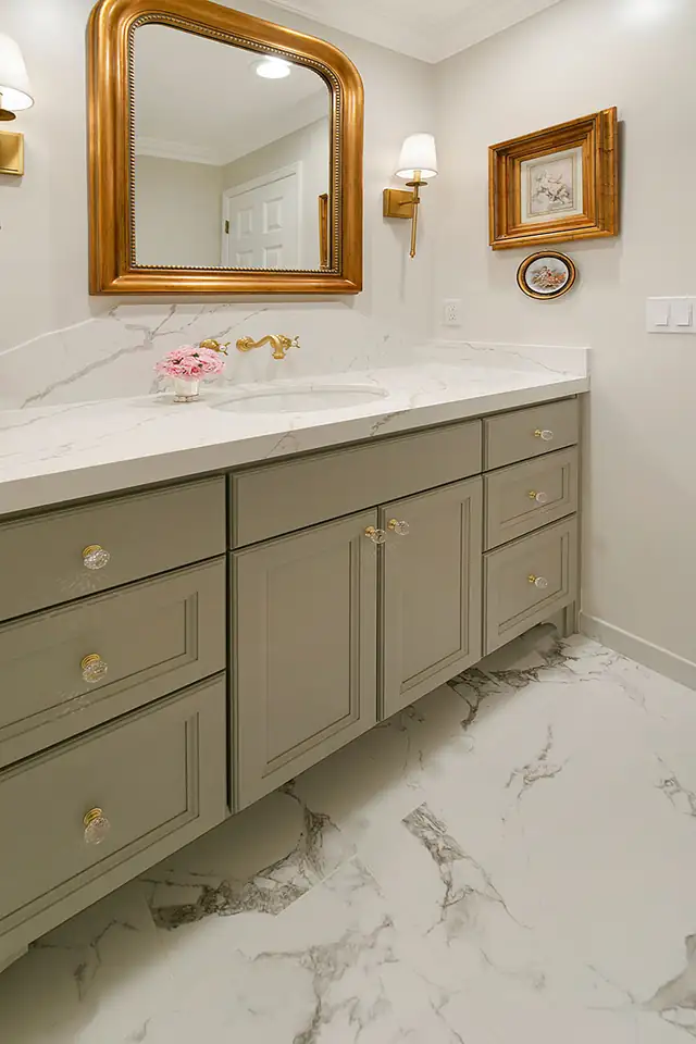 Transitional bathroom remodel in Blackhawk with sage green vanity, gold-framed mirror and marble-look floor tile